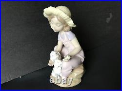 Lladro girl giving her dog a bone. 7 in. Tall. Excellent condition