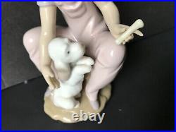 Lladro girl giving her dog a bone. 7 in. Tall. Excellent condition